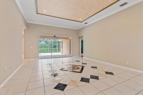 Sarasota house for rent - A spacious room with a tiled floor and a glass door leading outside.