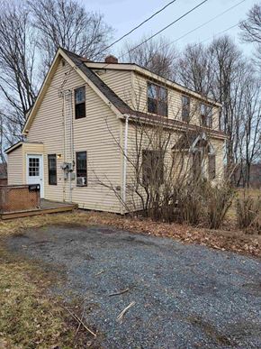 New Glasgow apartment for rent - a yellow house with a gravel driveway and bare trees