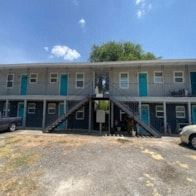 Killeen apartment for rent - an office building with blue doors and a parking lot