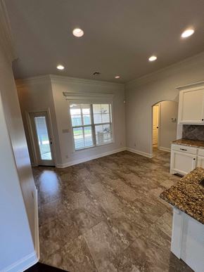 Lafayette house for rent - a kitchen and living room with white cabinets and a window