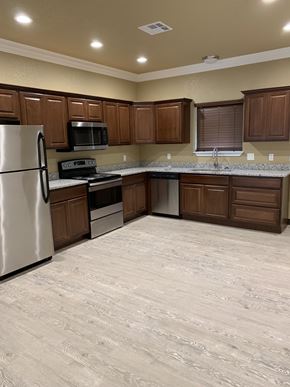 Durant house for rent - an empty kitchen with wooden cabinets and stainless steel appliances