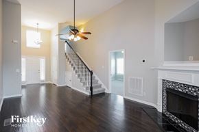 Clarksville house for rent - A spacious living room with a fireplace and a staircase.