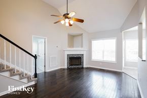 Clarksville house for rent - A spacious living room with a fireplace and a staircase.