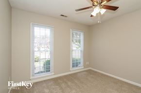 Charlotte house for rent - a bedroom with two windows and a ceiling fan