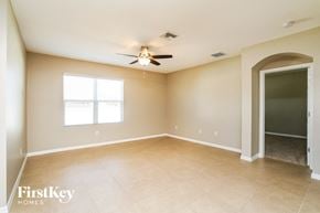 Cape Coral house for rent - an empty living room with a ceiling fan and a door to a closet