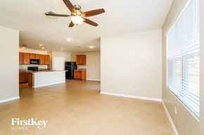 Cape Coral house for rent - an empty kitchen and living room with a ceiling fan
