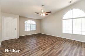 San Tan Valley house for rent - an empty living room with wood floors and a ceiling fan