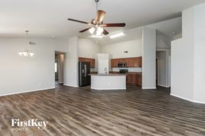 San Tan Valley house for rent - an empty living room with a ceiling fan and a kitchen