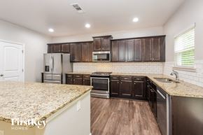 Canton house for rent - a kitchen with dark wood cabinets and granite counter tops and a sink