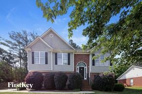 Winder house for rent - a house with hedges and a tree in front of it