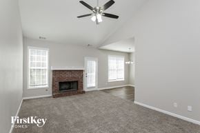 Winder house for rent - an empty living room with a brick fireplace and a ceiling fan