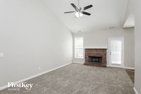 Winder house for rent - an empty living room with a fireplace and a ceiling fan
