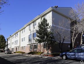 Aurora apartment for rent - A blue car is parked in front of a white building.