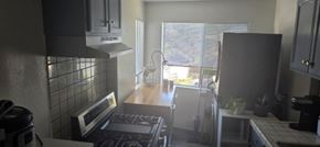Los Angeles apartment for rent - A kitchen with a stove top oven and a microwave.