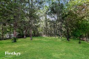 Charlotte house for rent - a large backyard with trees and a fence