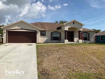 Cape Coral house for rent - a house with a driveway and a garage door