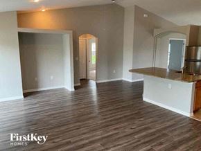 Cape Coral house for rent - an empty living room and kitchen with a wood floor