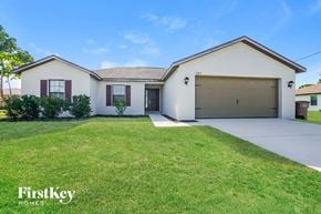 Cape Coral house for rent - A white house with a garage is for sale by FirstKey Homes.