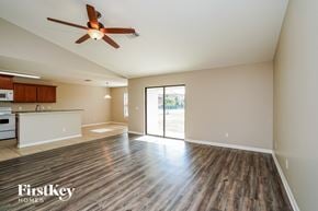 Cape Coral house for rent - A spacious room with wooden flooring and a ceiling fan.