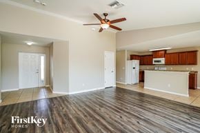 Cape Coral house for rent - A spacious living room with wood flooring and a ceiling fan.