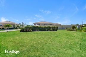 Cape Coral house for rent - A grassy area with a house and a sign that says "FirstKey Homes".
