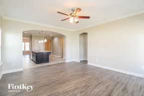 Winston-Salem house for rent - A spacious room with a ceiling fan and wooden flooring.