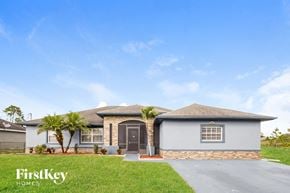 Lehigh Acres house for rent - a house with palm trees in front of it