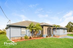 Lehigh Acres house for rent - a blue house with palm trees in front of it