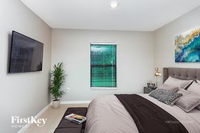 North Port house for rent - A bedroom with a large bed and a painting on the wall.