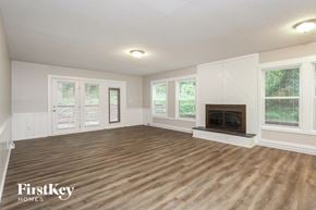 Lewisville house for rent - A spacious living room with a fireplace and wooden flooring.
