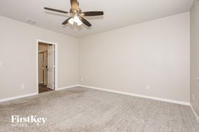 New Smyrna Beach house for rent - A spacious room with a ceiling fan and carpeted floor.