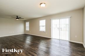 Jacksonville house for rent - an empty living room with wood floors and a ceiling fan