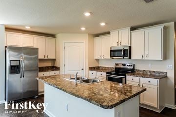 Jacksonville house for rent - a kitchen with white cabinets and granite counter tops