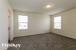Jacksonville house for rent - a bedroom with a carpeted floor and two windows