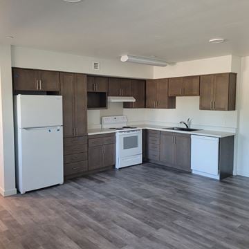 Ontario apartment for rent - an empty kitchen with white appliances and wooden cabinets
