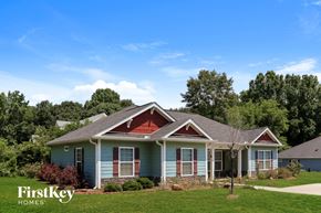 Douglasville house for rent - a blue house with a red roof and green grass and trees