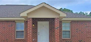 Hattiesburg house for rent - A red brick house with a white door and windows.