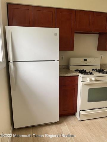 Keansburg apartment for rent - A white refrigerator stands next to a stove in a kitchen.