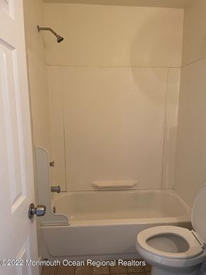 Keansburg apartment for rent - A white bathroom with a toilet and a bathtub.