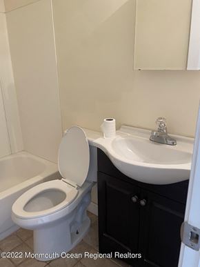 Keansburg apartment for rent - A white toilet sits next to a white sink in a bathroom.
