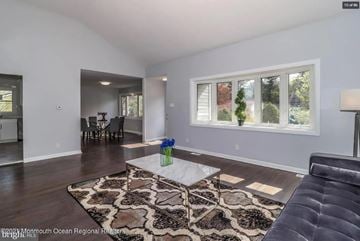 Cherry Hill house for rent - A living room with a black couch and a patterned rug.