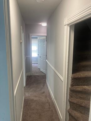 Mount Holly apartment for rent - A hallway with a staircase on the right and a door at the end.