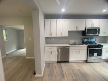 Stratford apartment for rent - A kitchen with white cabinets and a wooden floor.