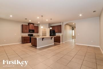 Orange City house for rent - an open kitchen and living room with tile flooring and wooden cabinets