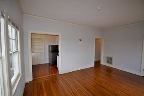 Oakland apartment for rent - a living room with a hard wood floor and a door to a bedroom