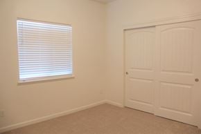 Merced house for rent - A room with a white door and a window with blinds.