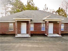 Hattiesburg house for rent - A small brick house with a white door and windows.