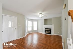 Raleigh house for rent - an empty living room with a fireplace and a ceiling fan