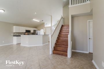 Orange Park house for rent - A spacious kitchen with a staircase leading to the upper floor.