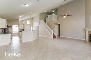 Orange Park house for rent - A spacious living room with a staircase and a kitchen area.